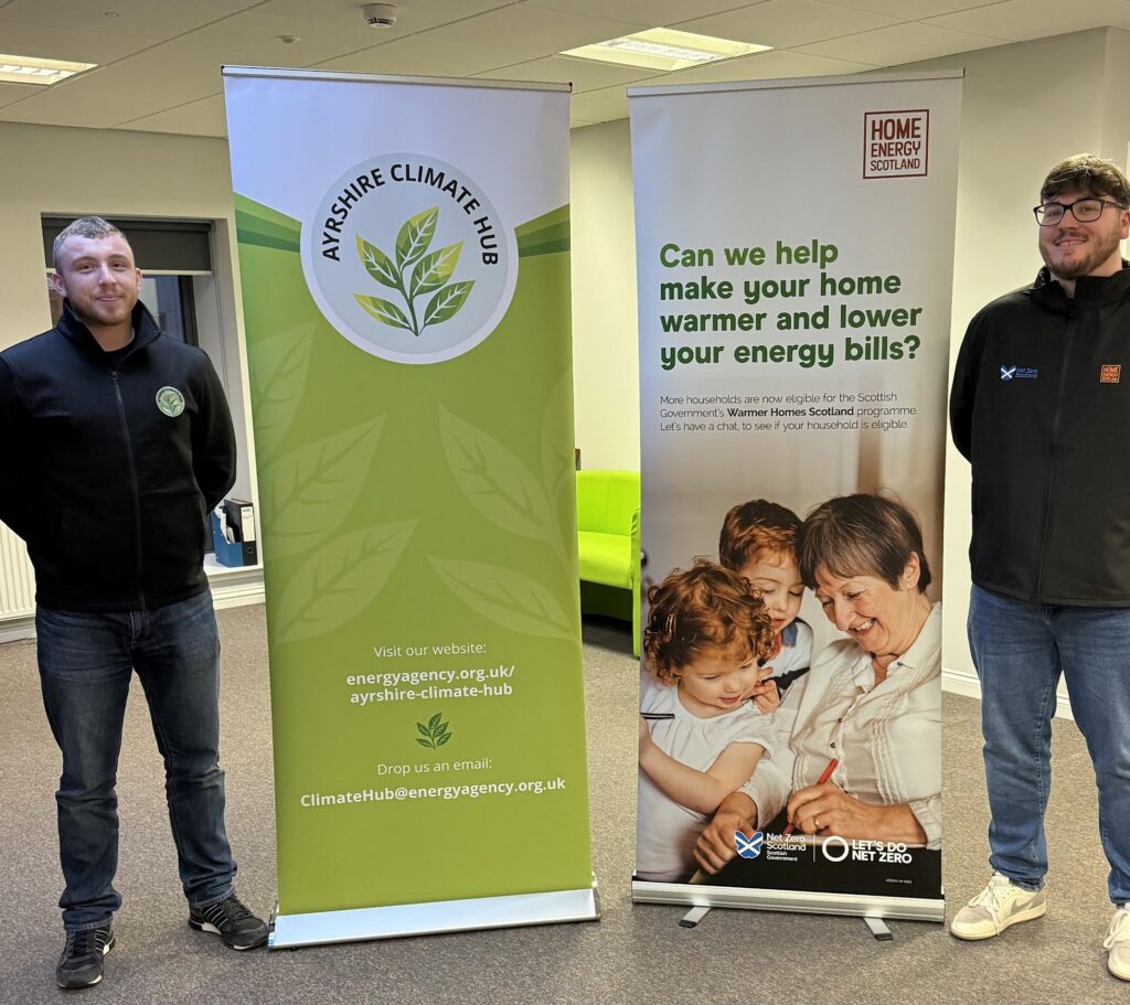 Two people standing next to large banners.