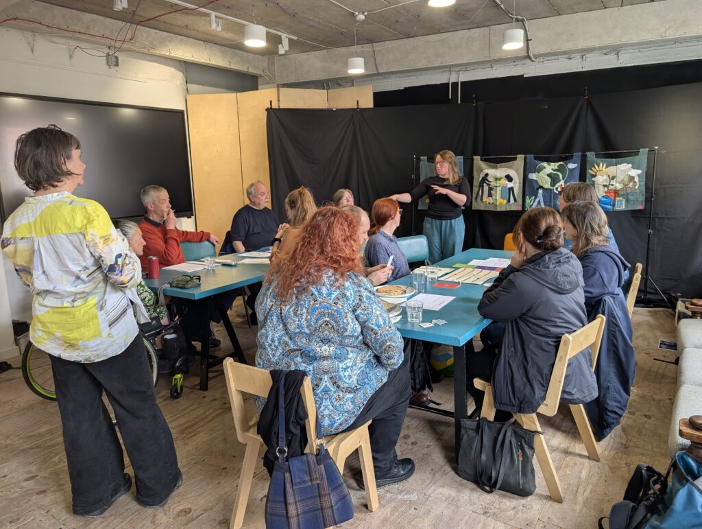 Several people in a room playing a game round a table